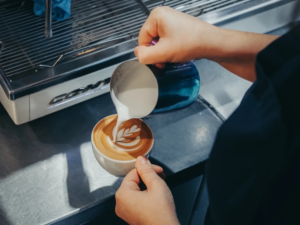 Barista pouring latte art at Pistachios in the Park